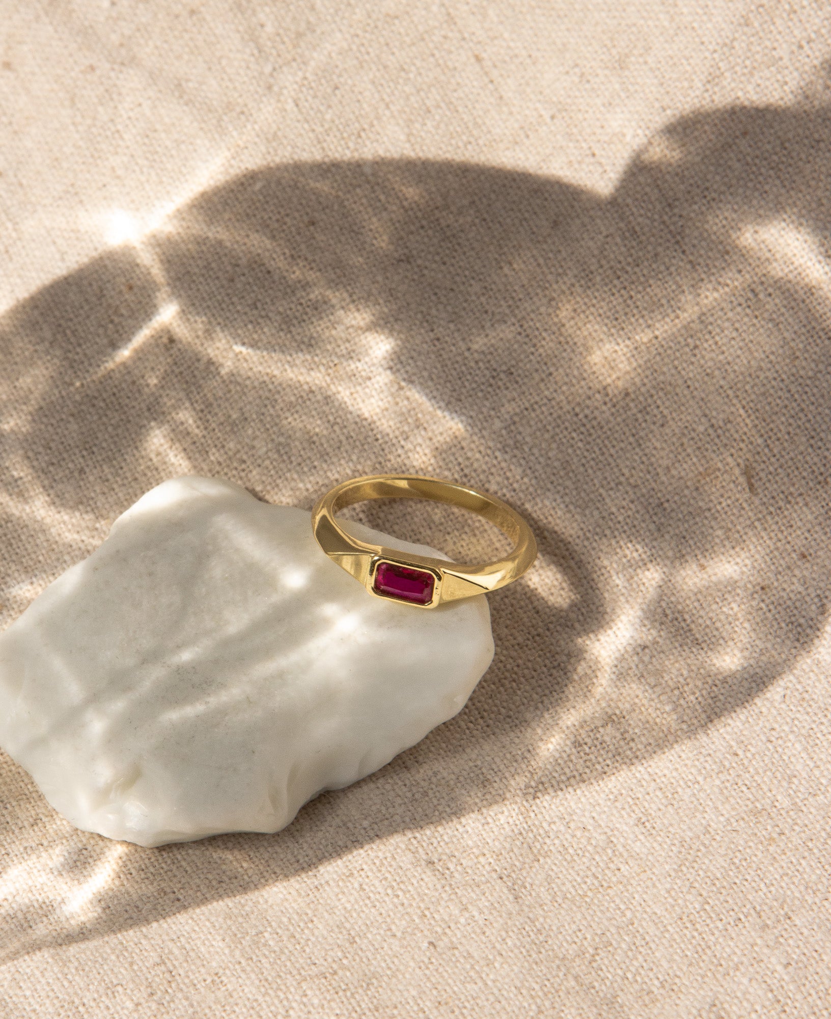close up of the winnie baguette signet ring with ruby cubic zirconia stone details