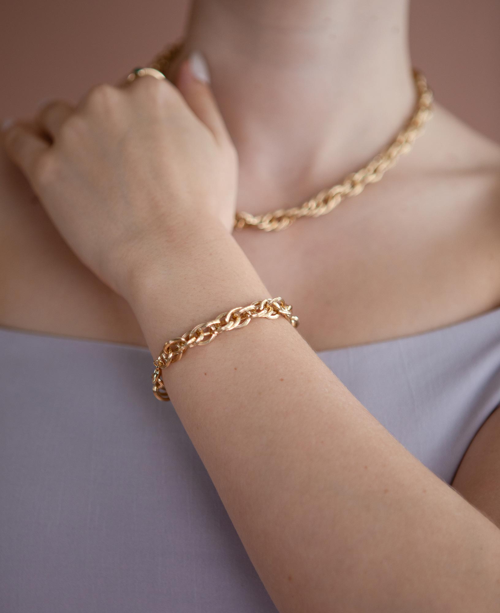 close up model shot of emma chunky chain gold necklace and ollie chunky chain gold bracelet
