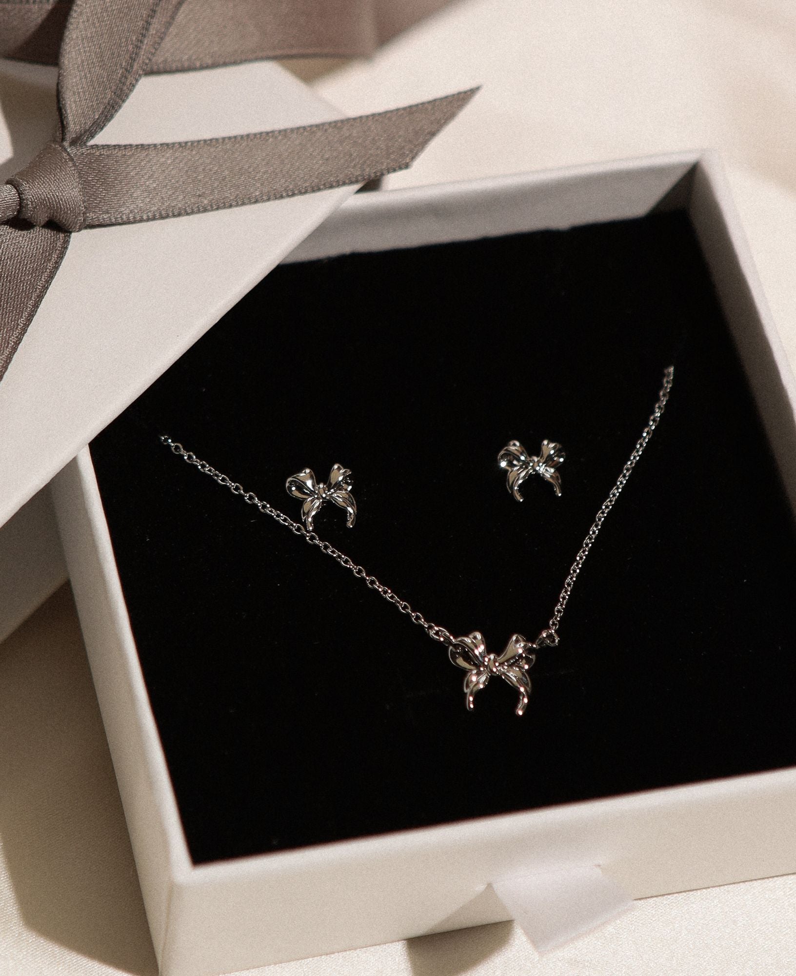 matching set of Daphne Silver Ribbon Earrings with Juliet Silver Ribbon Necklace