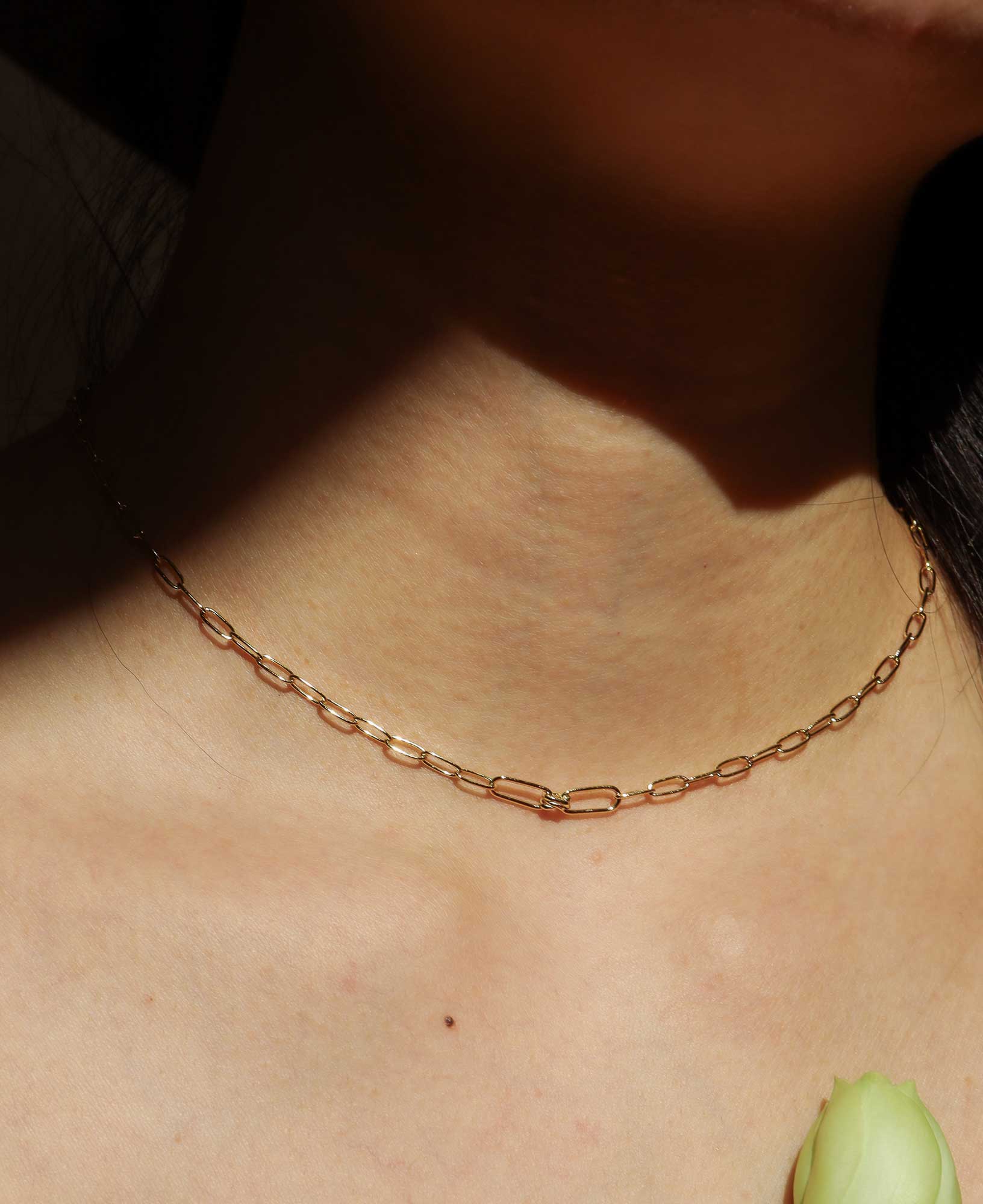 the Charlene Love Knot Gold Paperclip Chain Necklace featured on a model.