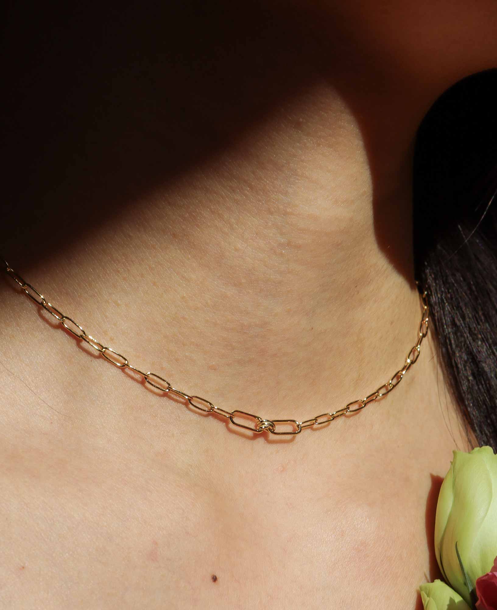 the Charlene Love Knot Gold Paperclip Chain Necklace featured on a model.