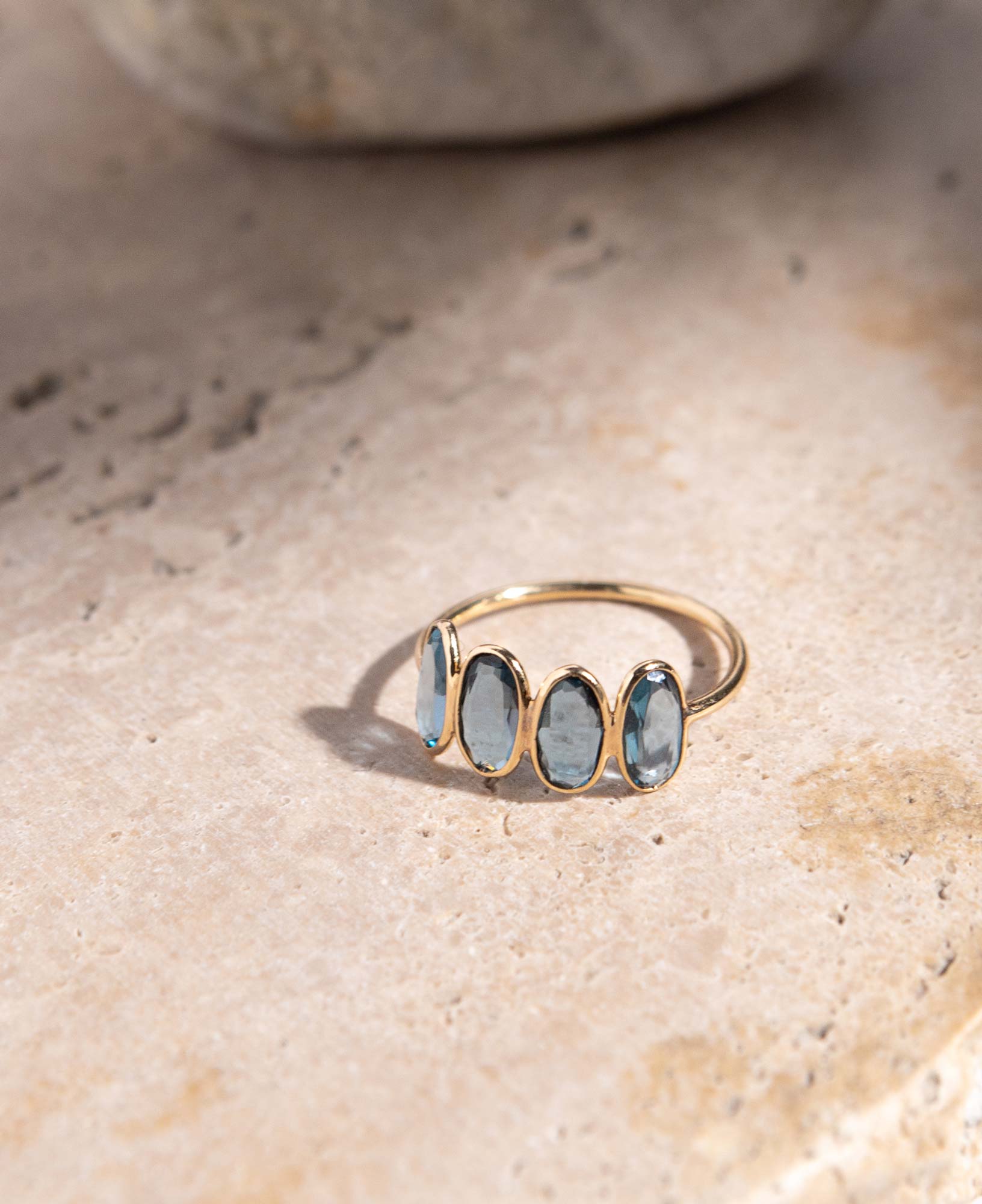 lifestyle flatlay shot of marjorie blue topaz solid gold ring