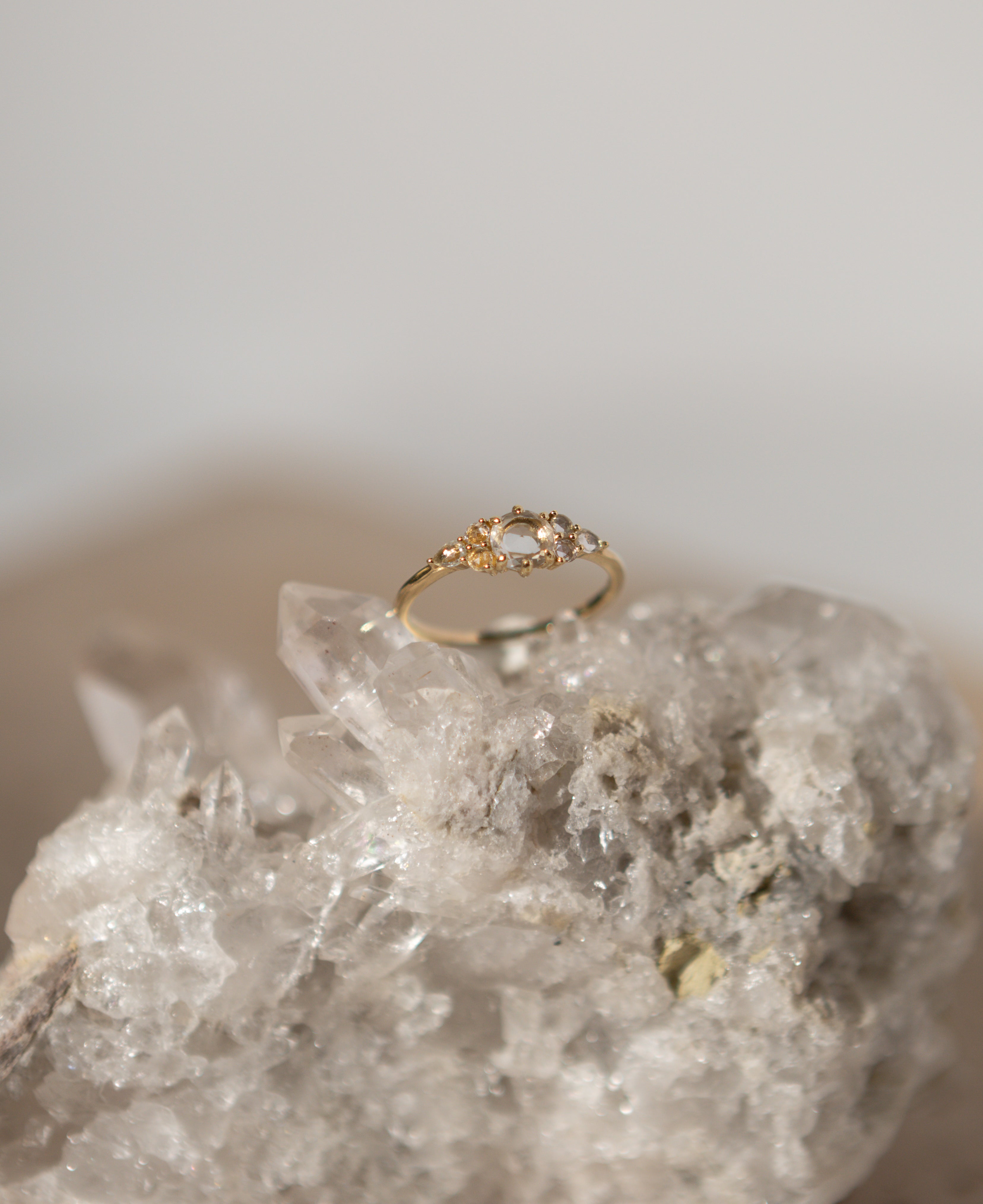 lifestyle product shot of josephine white sapphire cluster solid gold ring