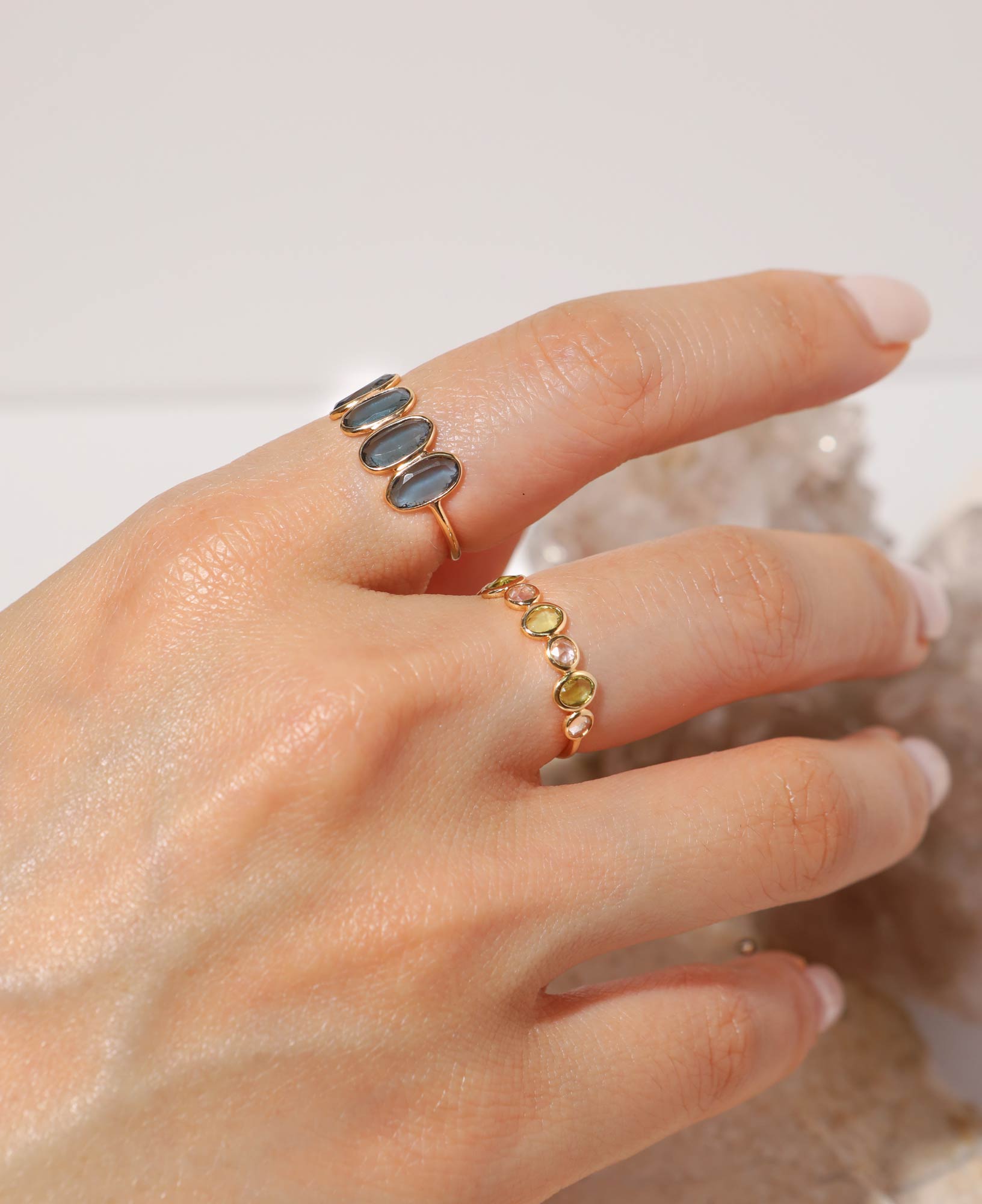 model shot of genevieve half eternity solid gold ring and marjorie blue topaz solid gold ring