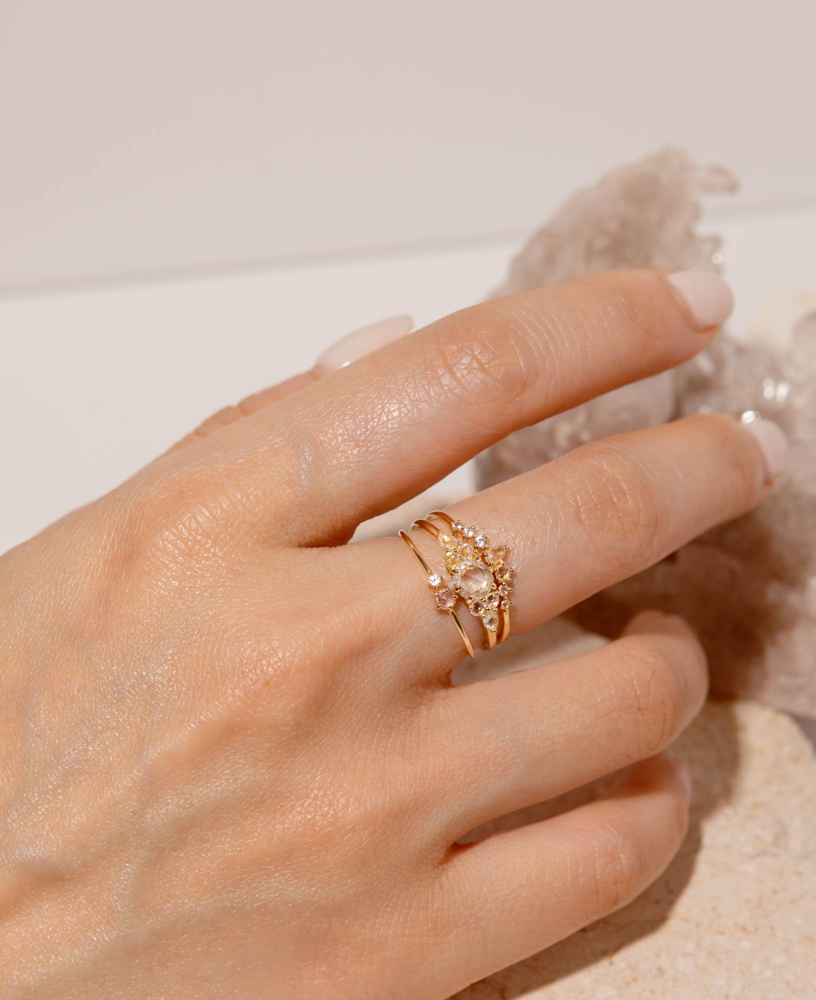 model shot of josephine white sapphire cluster solid gold ring, ophelia white sapphire solid gold ring and cleo white sapphire solid gold ring