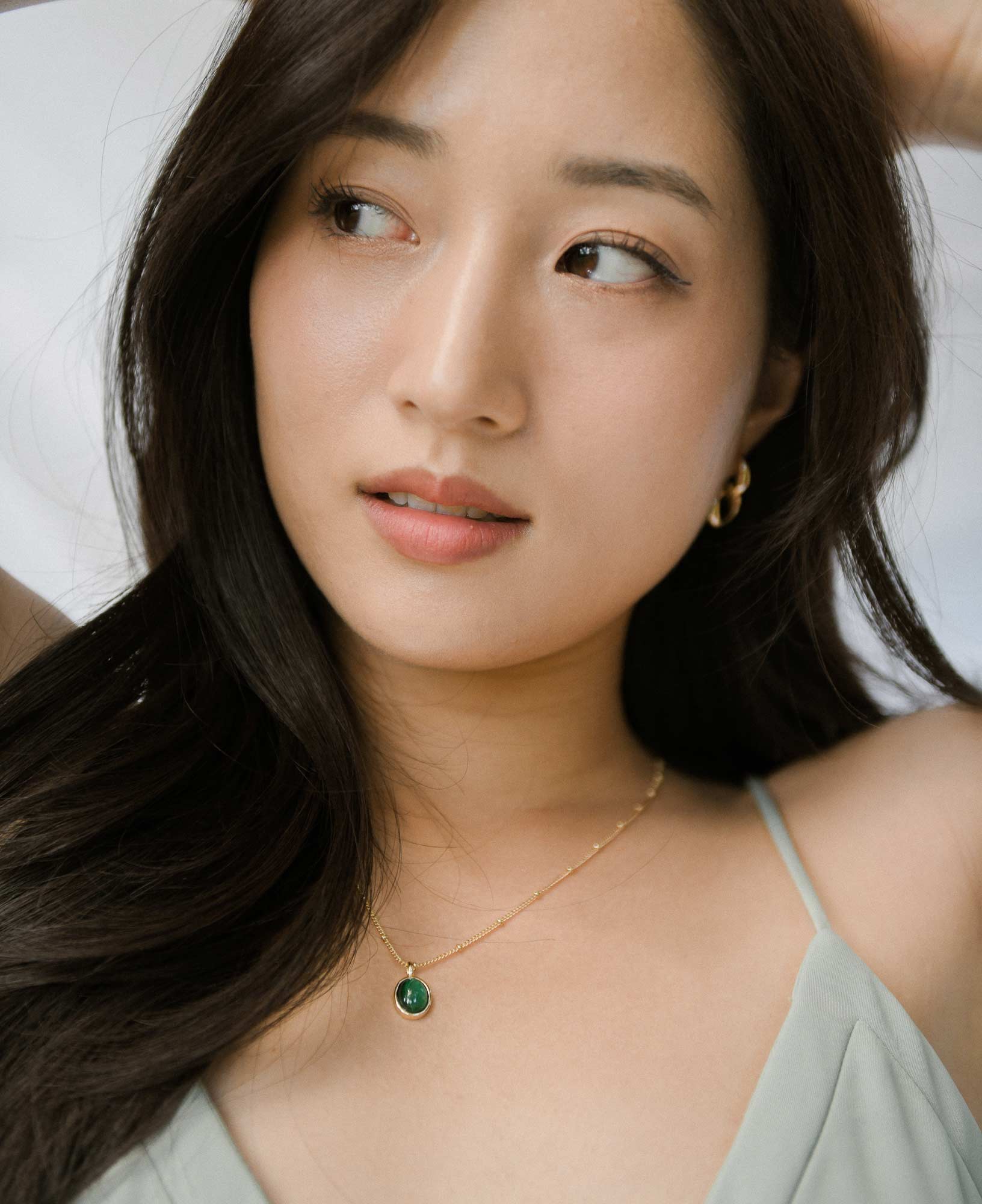 model shot of Sally Kim wearing the Haru Malachite Bezel Necklace and the Hannah Interchangeable Gold Hoop Earrings