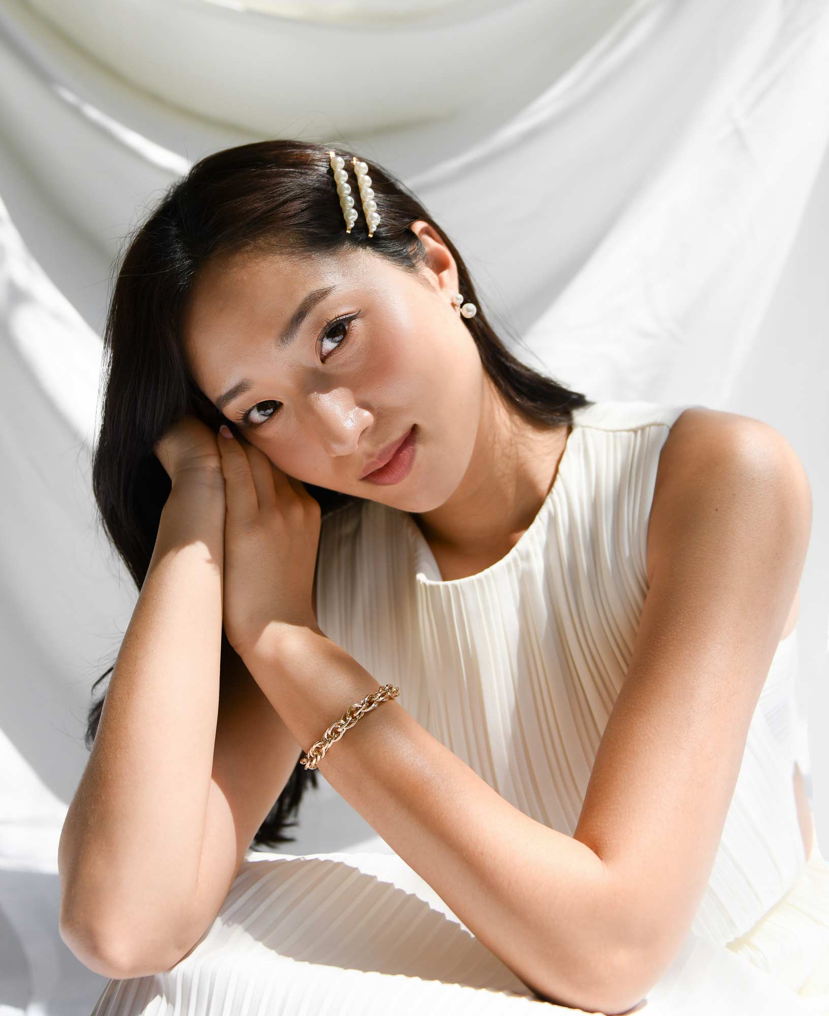 model shot of sally kim wearing the ollie gold chunky chain bracelet and the Young Pearl Jacket Earrings