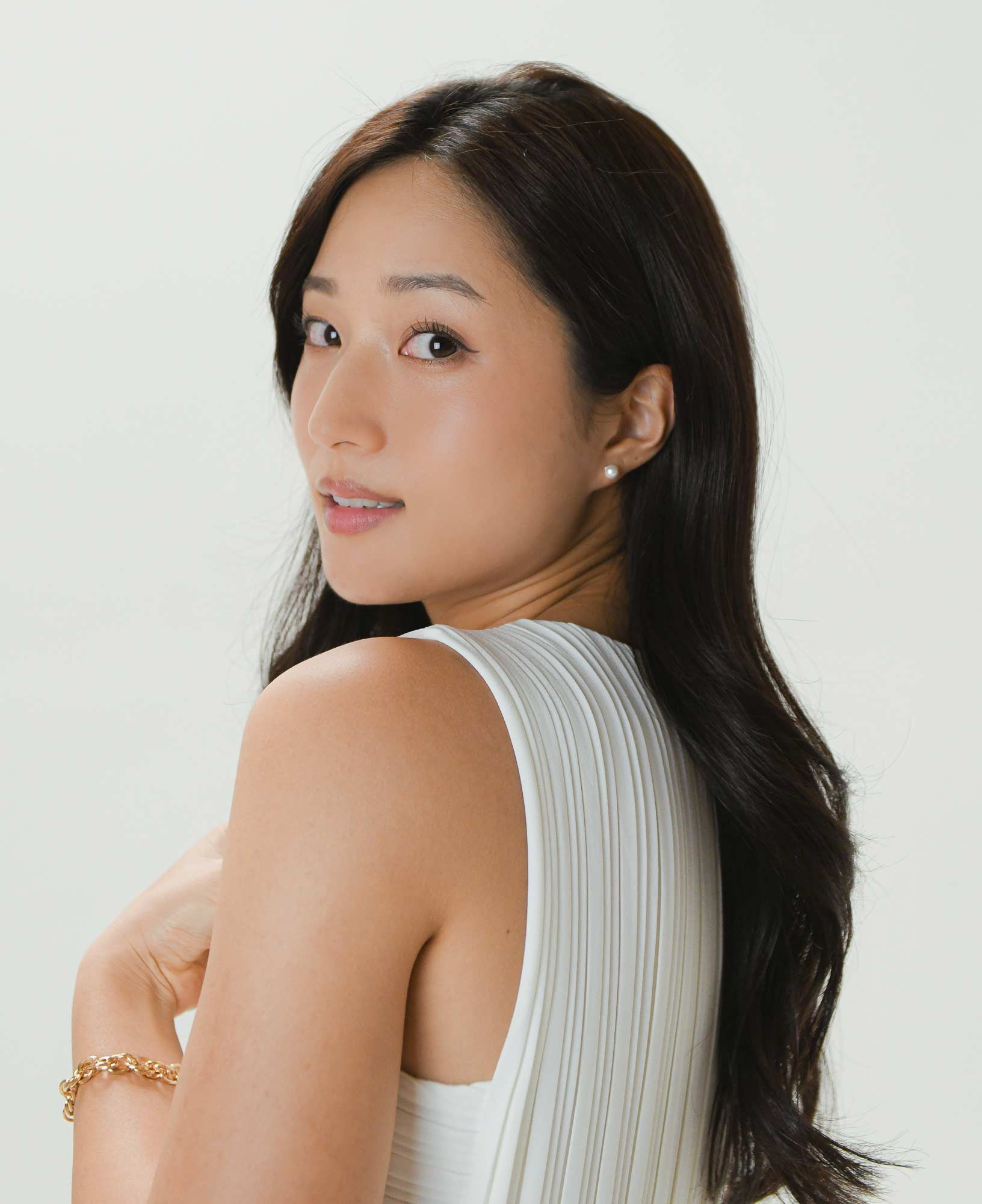 model shot of sally kim wearing the young pearl jacket earrings and the ollie gold chunky chain bracelet