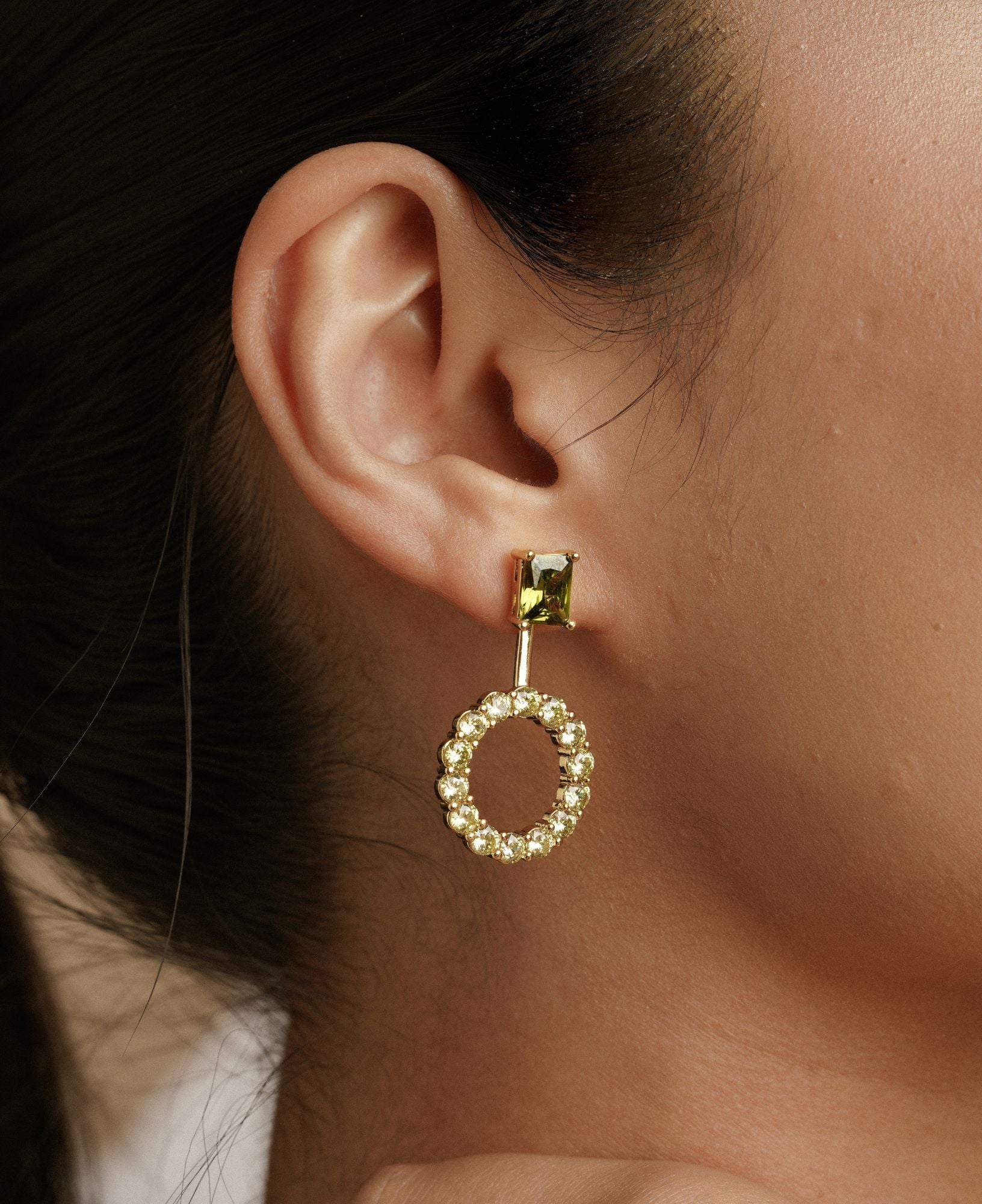 close-up shot of a model wearing the Astrid Peridot Studs with Round Jacket.