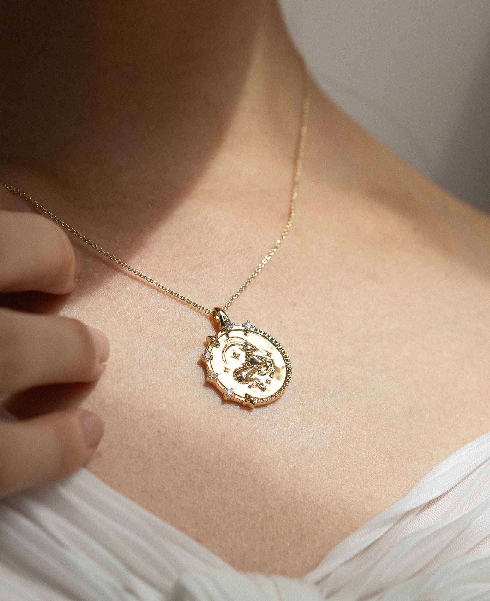 styling the capricorn horoscope gold pendant necklace on a model.