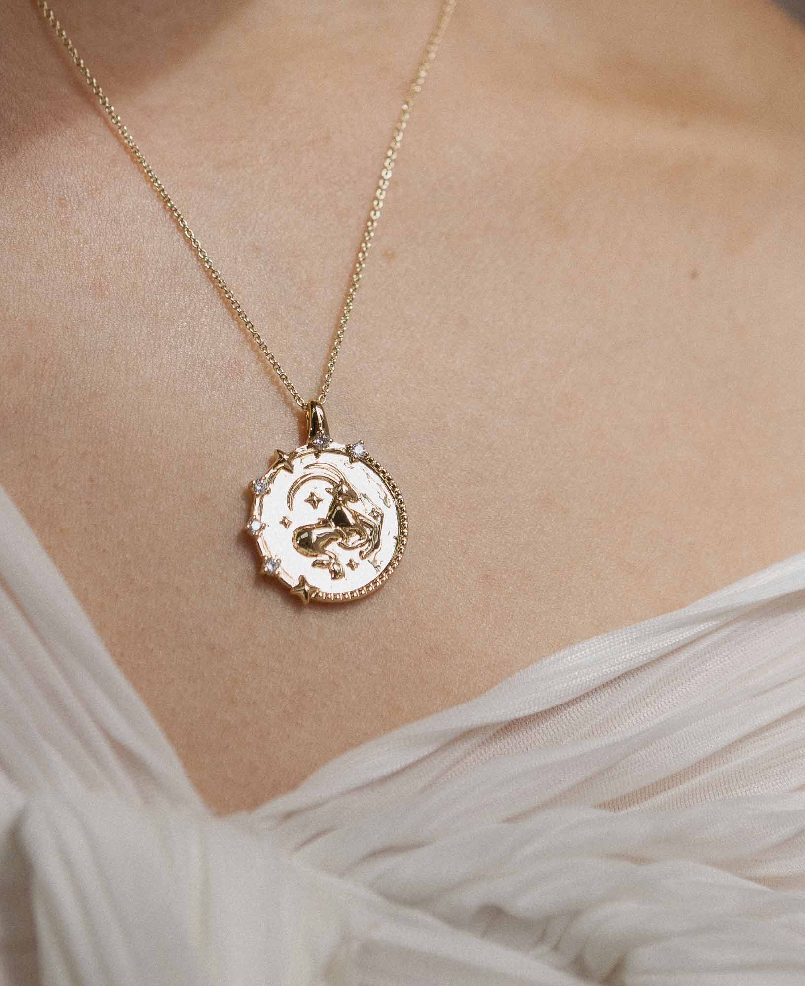 close-up image of styling the capricorn horoscope gold pendant necklace on a model.