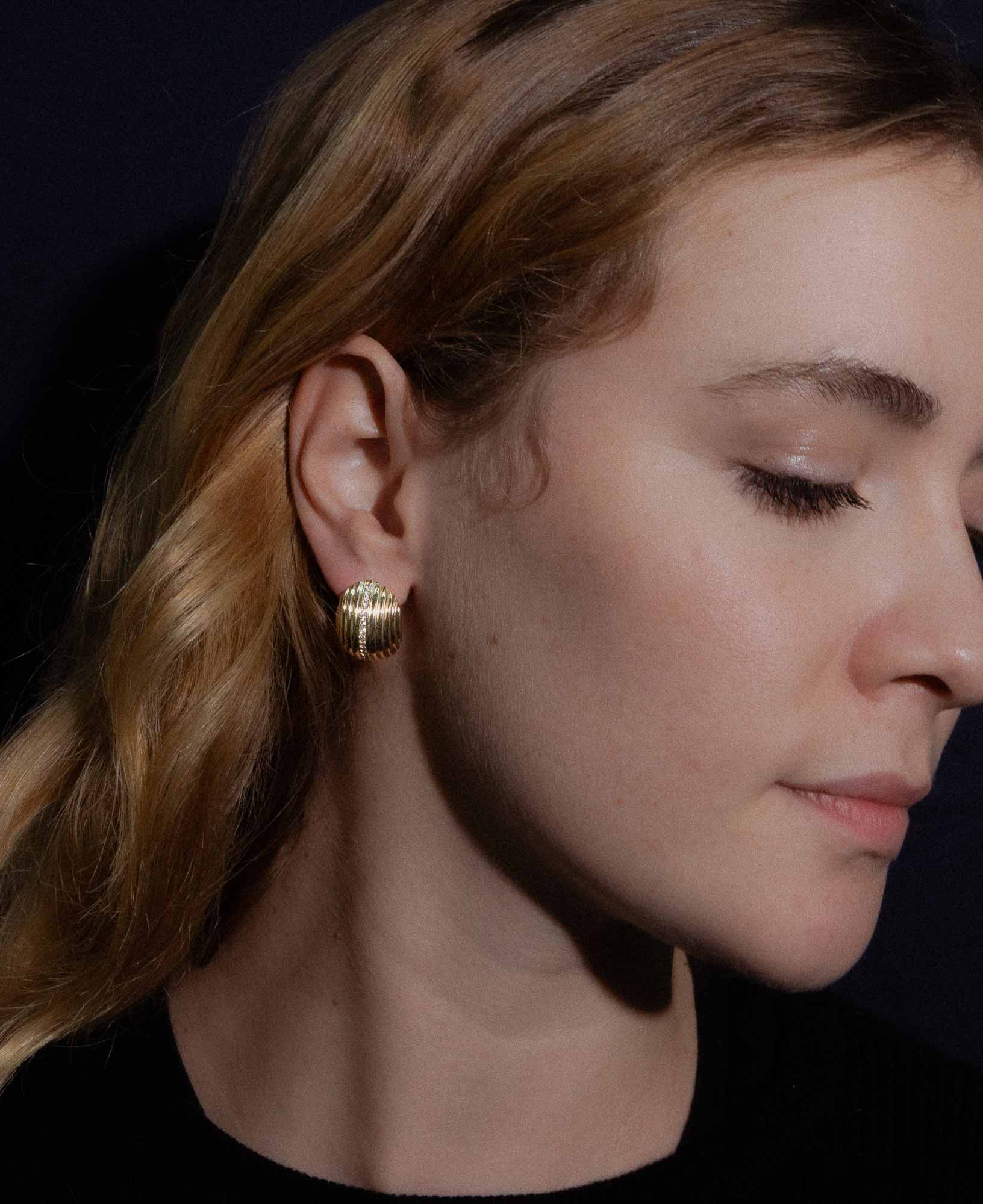 Dark and festive close-up shot in the studio featuring the Cordelia Wide Ribbed CZ Button Earrings.