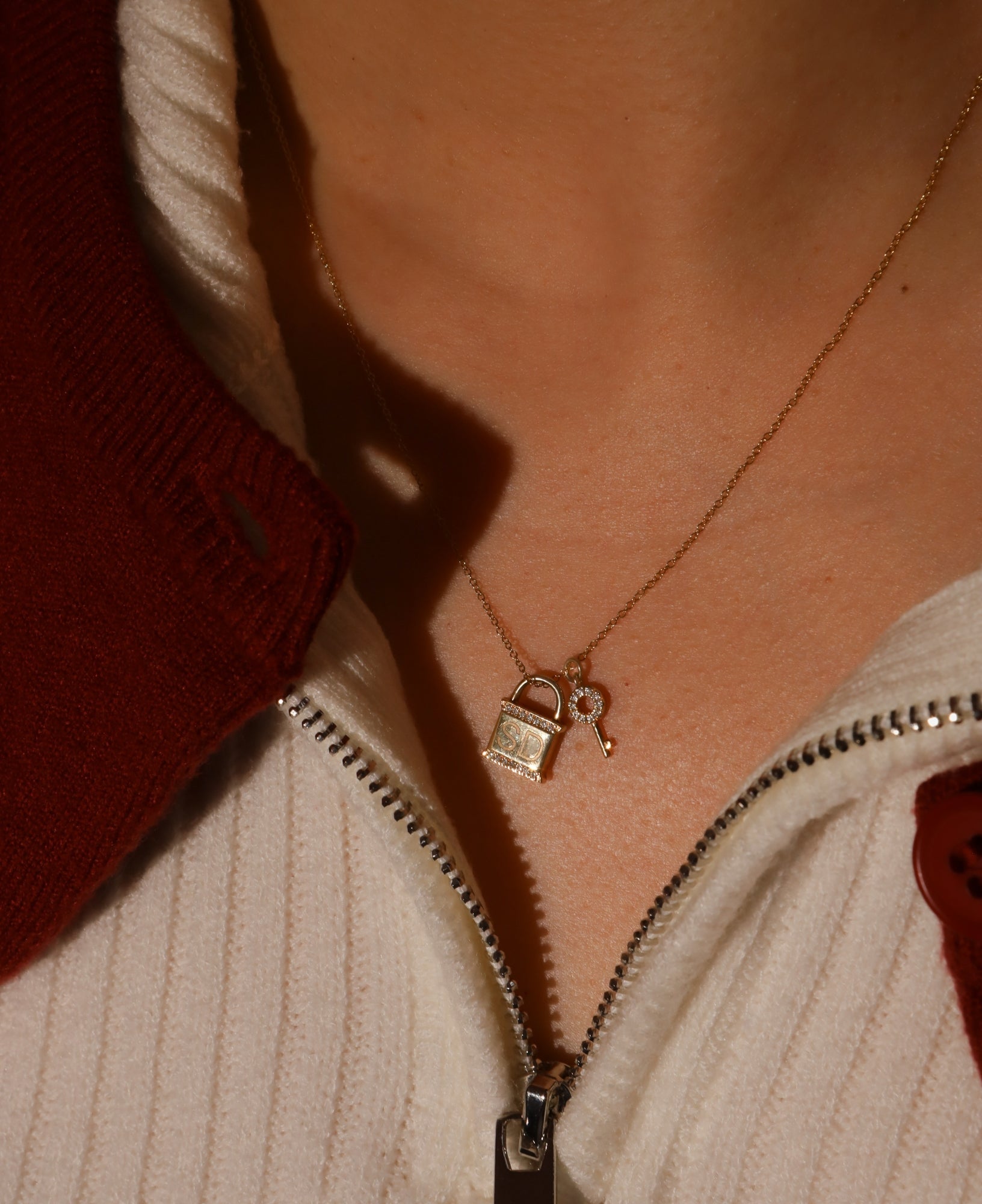 Necklace with a lock pendant worn by a person, with a blurred background.