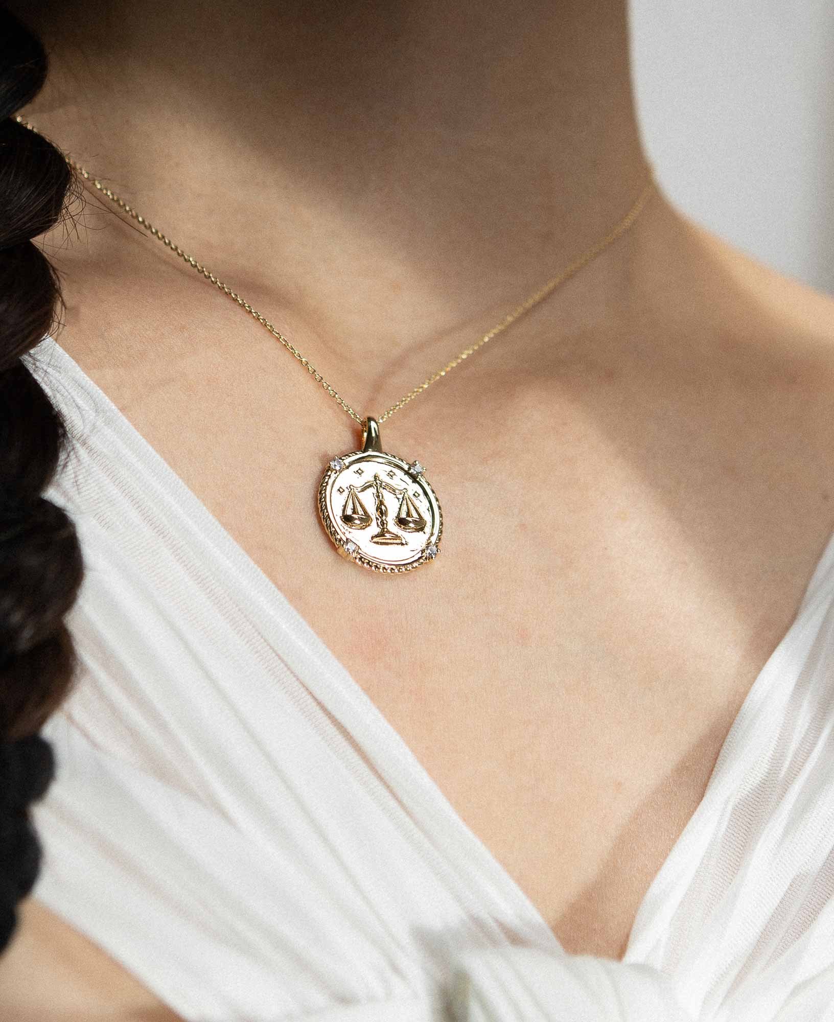 styling the libra horoscope gold pendant necklace on a model.