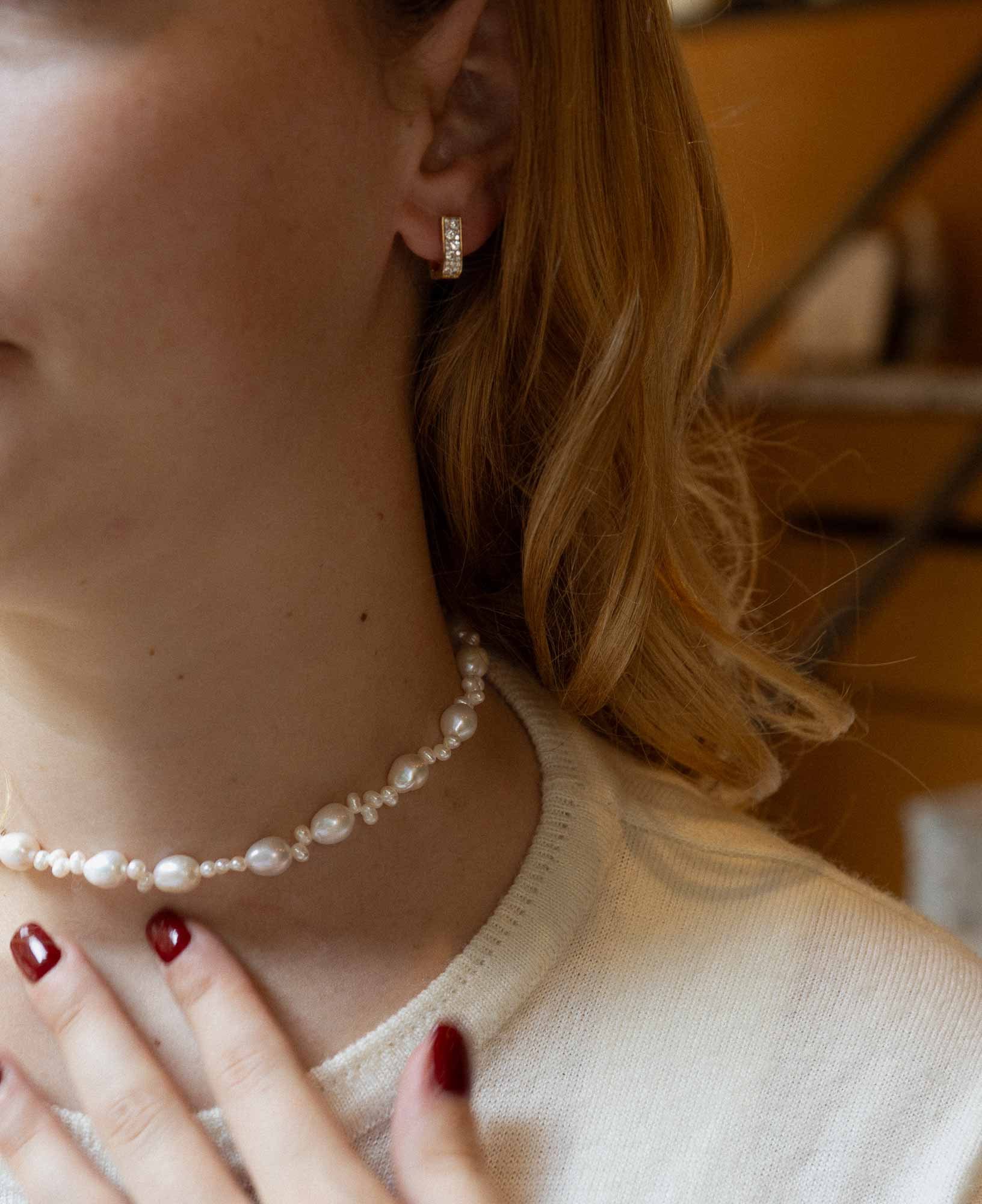 close-up shot featuring the Paloma Reversible CZ Huggie Hoop Earrings and Emilia Baroque Pearl Choker Necklace.