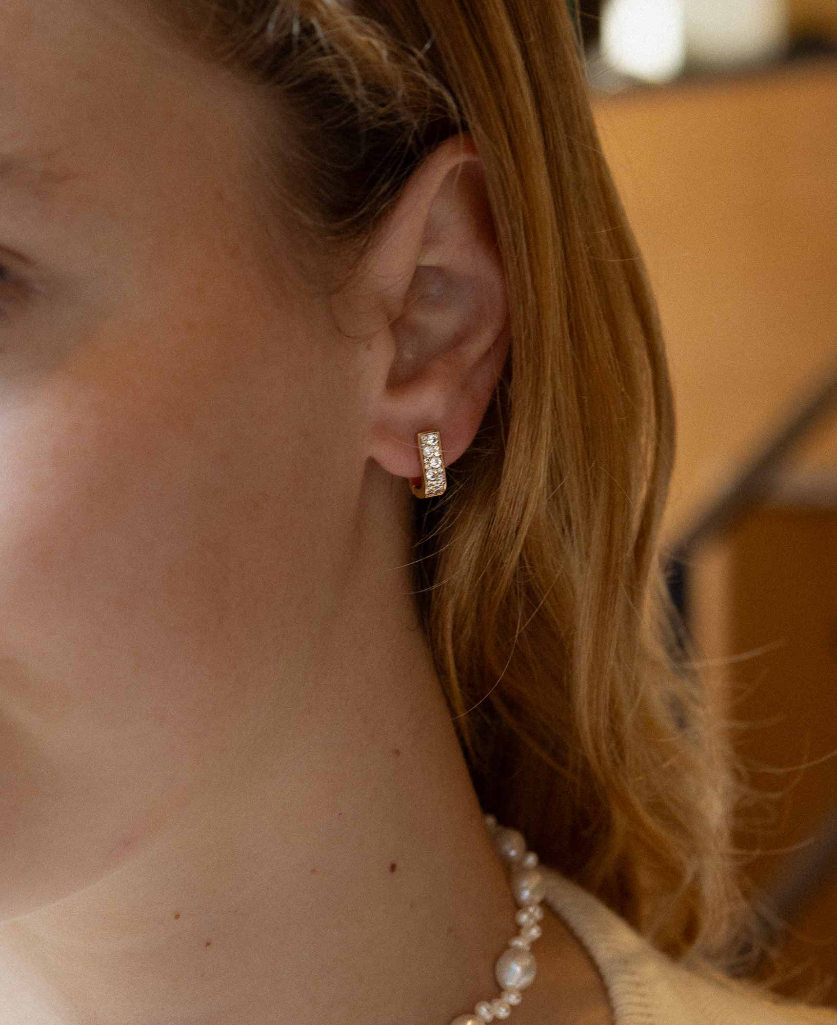 Close-up shot of the Paloma Reversible CZ Huggie Hoop Earrings.