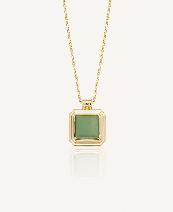 Gold necklace with a green gemstone square pendant on a white background