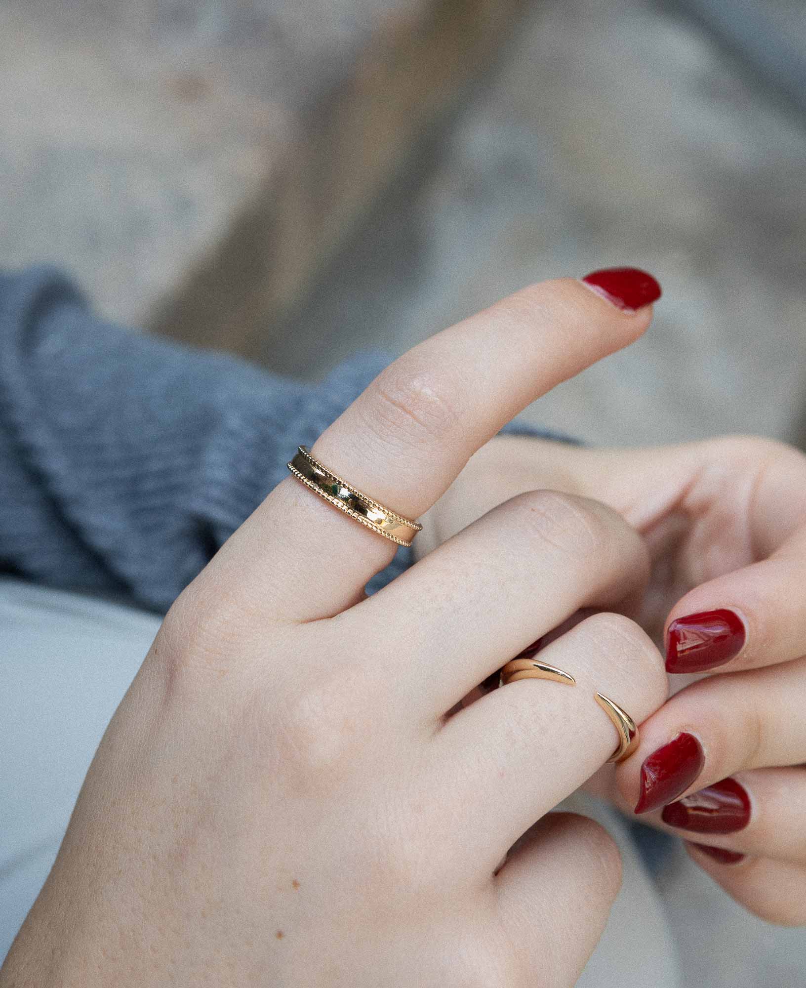 close-up shot of model's hand featuring the Gladys Beaded Gold Band Ring, Imogen Gold Cuff Open Ring.