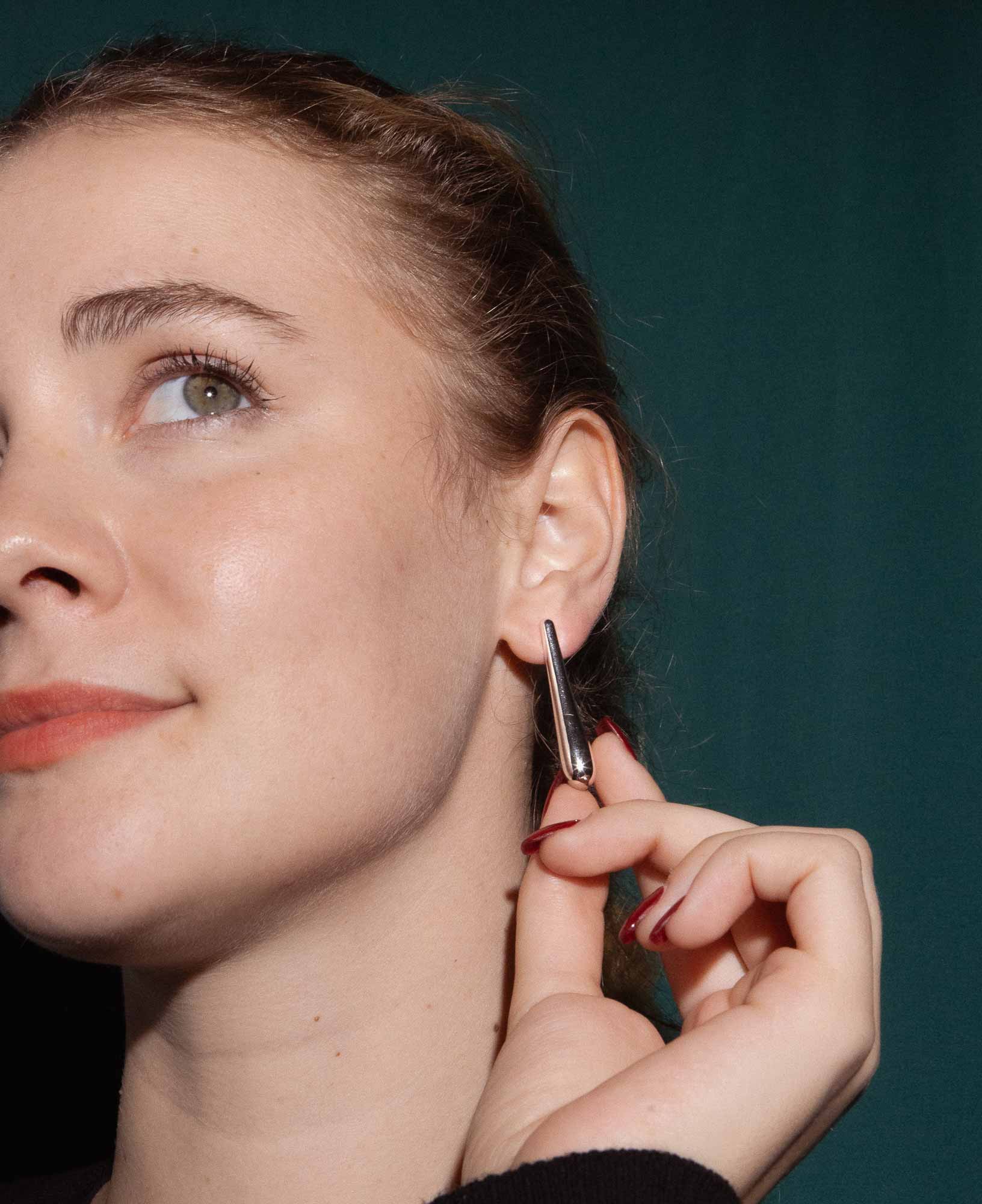 dark and festive close-up shot in the studio featuring the Sybil Silver Droplet Stud Earrings.