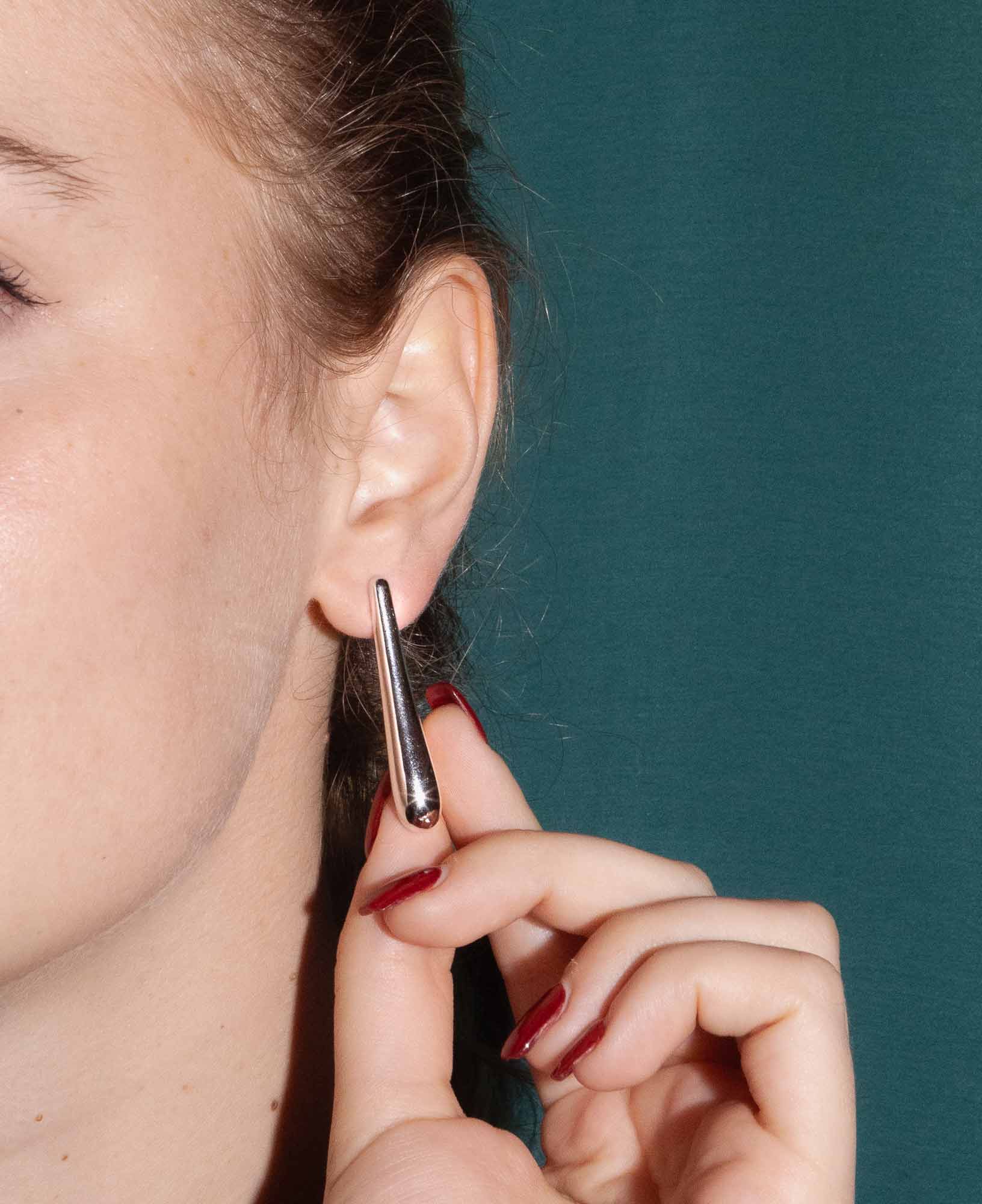 dark and festive close-up shot in the studio featuring the Sybil Silver Droplet Stud Earrings.