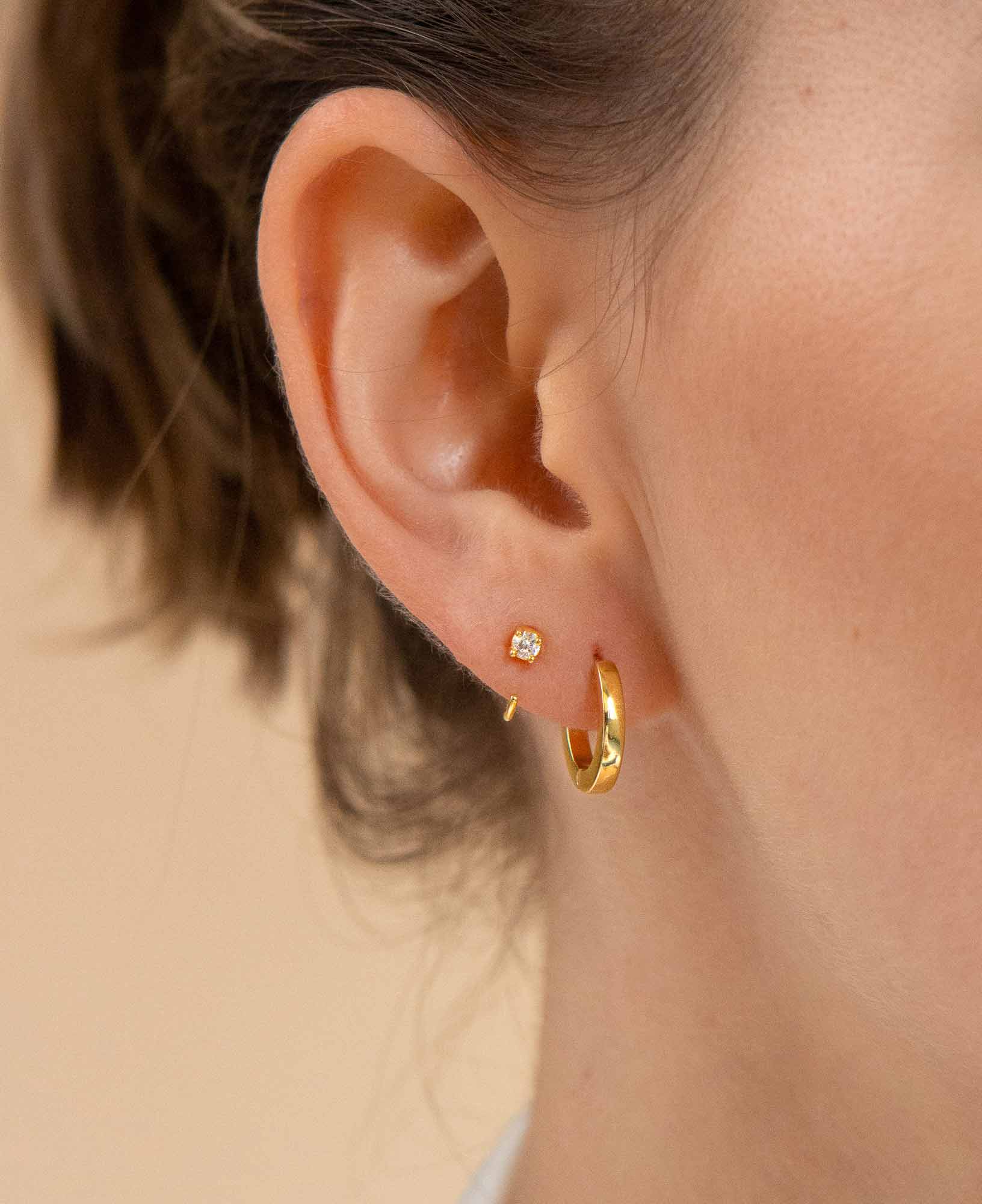 Model wearing giselle half moon mini hoop earrings