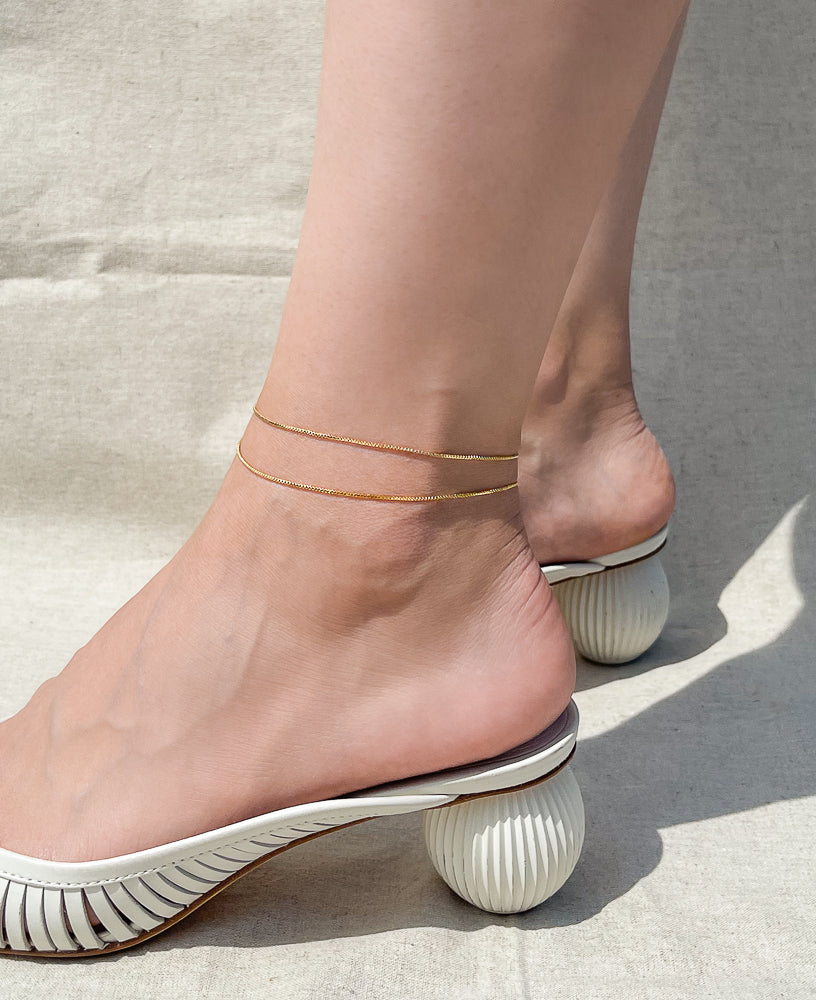 Model wearing Carmine 14k gold-filled anklet from Sachelle Collective, sustainable jewelry brand