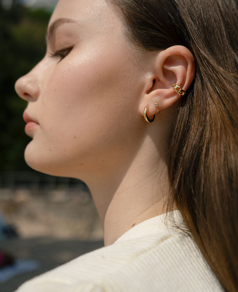 outdoor shot of model wearing the lenette 14k gold chain ear cuff