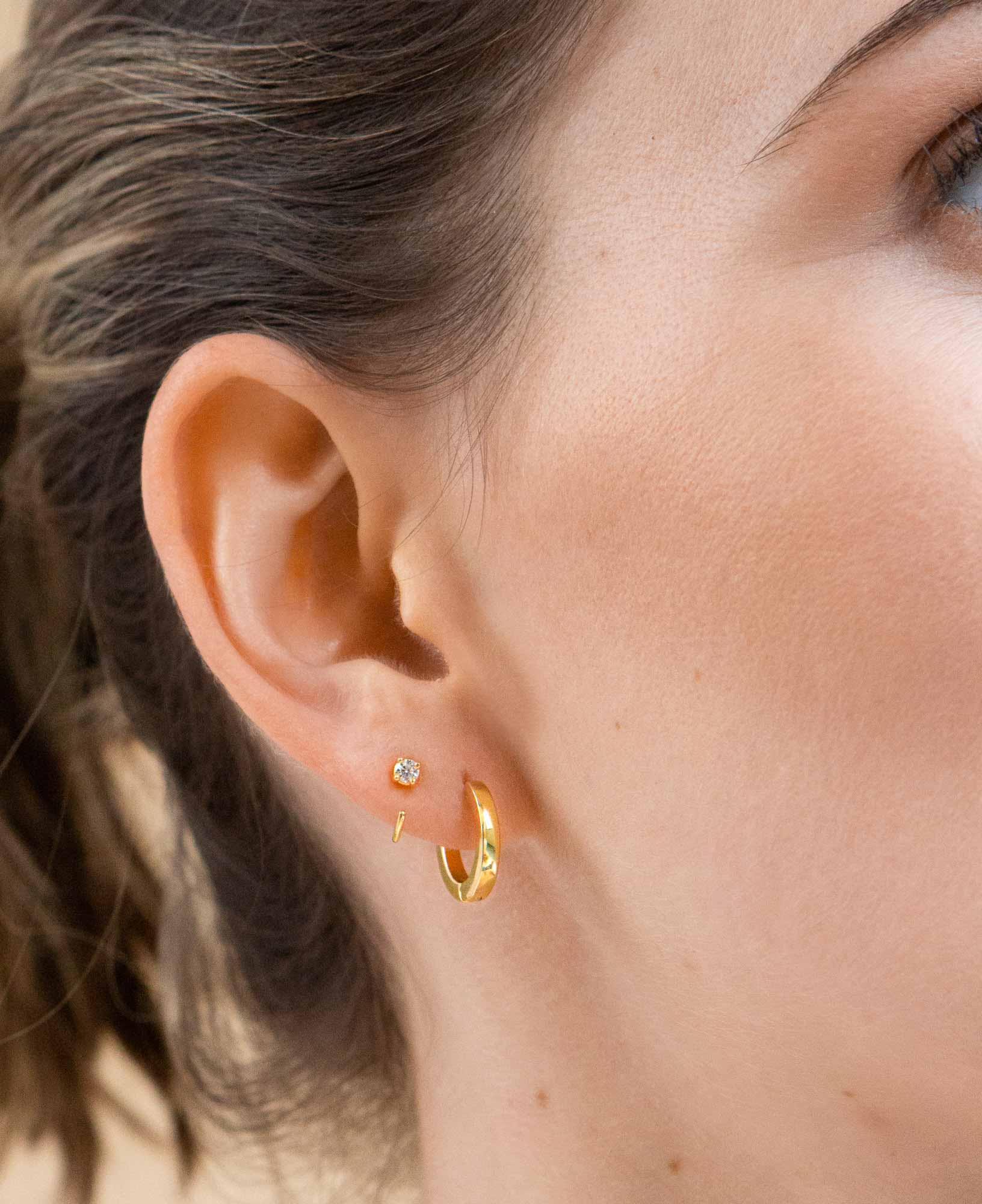 Close up of model wearing dainty giselle half moon hoops