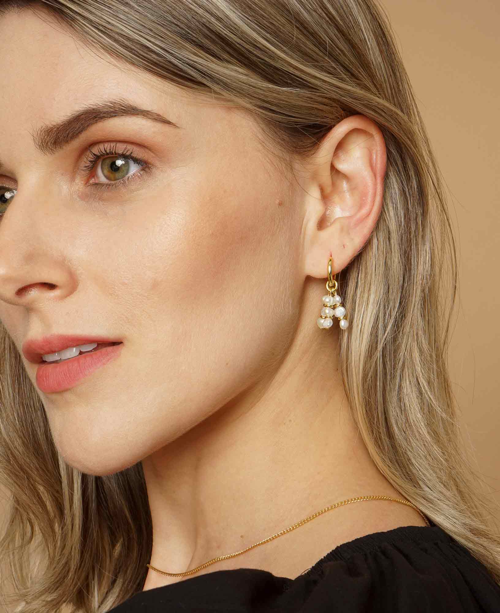 Side angle of model wearing ines pearl hoop earrings